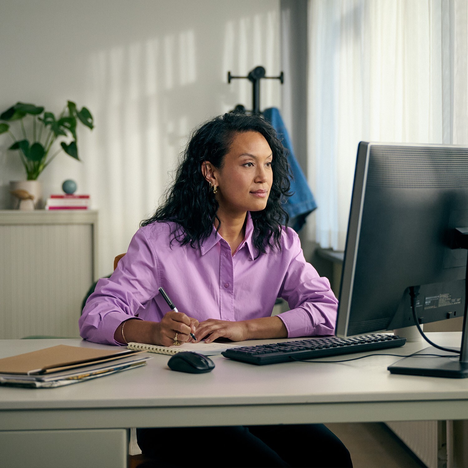 GGZ-behandelaar maakt aantekeningen achter computer tijdens een online consult